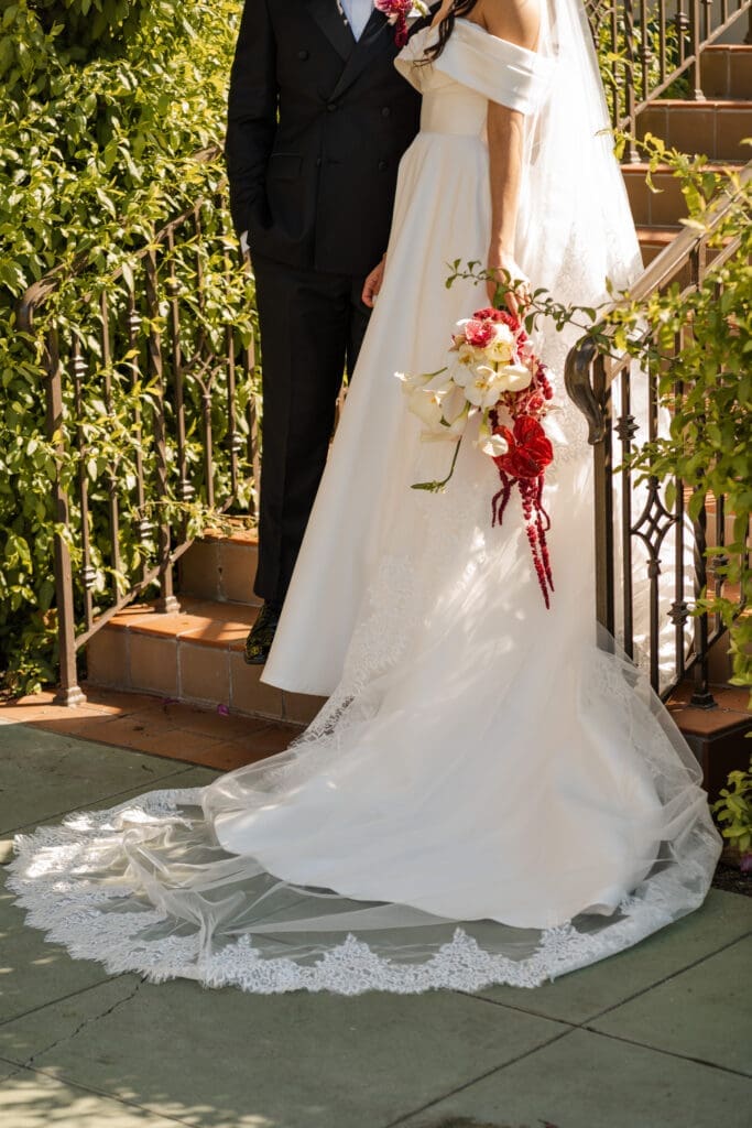 Bride and groom wedding day outfit details with orchid bouquet.