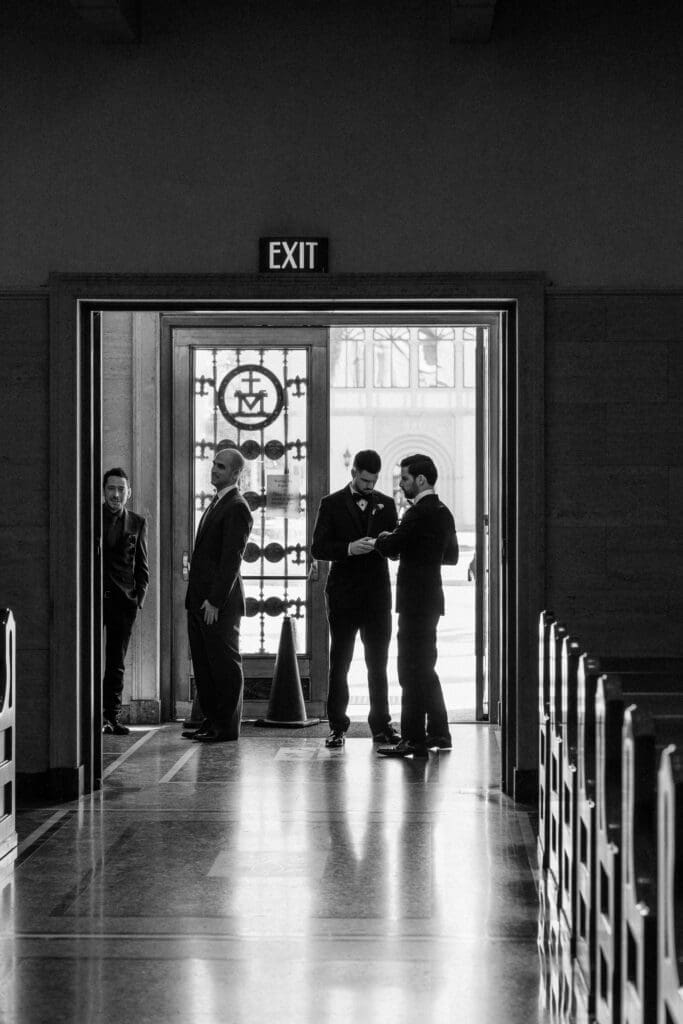 Groomsmen waiting for arrival of the groom inside the church.