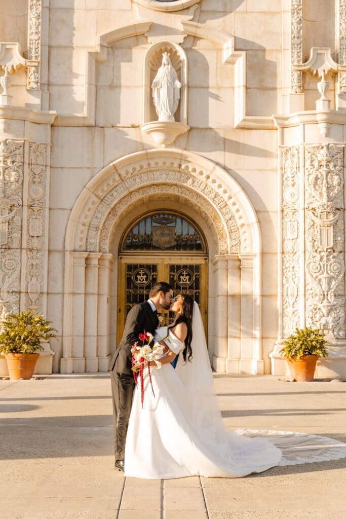Wedding day kiss outside Immaculata Catholic Church in San Diego, California
